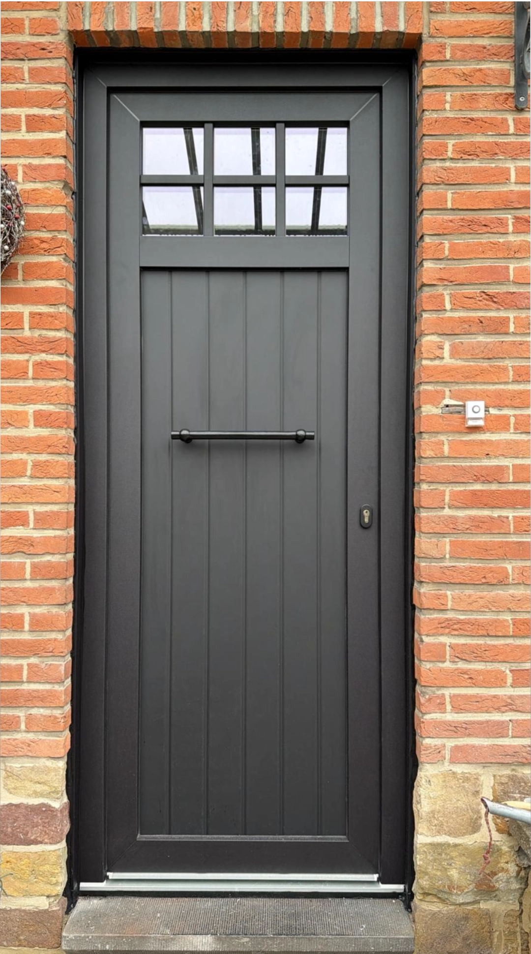Porte d’entrée PVC noire posée à Watermael-Boitsfort avec finitions intérieures sur-mesure